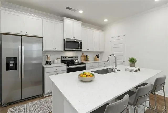 a kitchen with stainless steel appliances a refrigerator sink stove microwave and cabinets