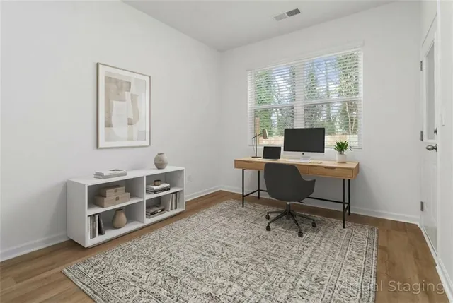 a view of a workspace with furniture and a window