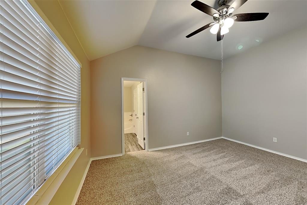 314 South Chestnut Street Forney, TX 75126 - Photo 6 of 18 Unfurnished bedroom with lofted ceiling, carpet floors, a ceiling fan, and connected bathroom