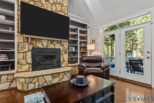 a kitchen with stainless steel appliances granite countertop a stove top oven a sink dishwasher a dining table and chairs with wooden floor