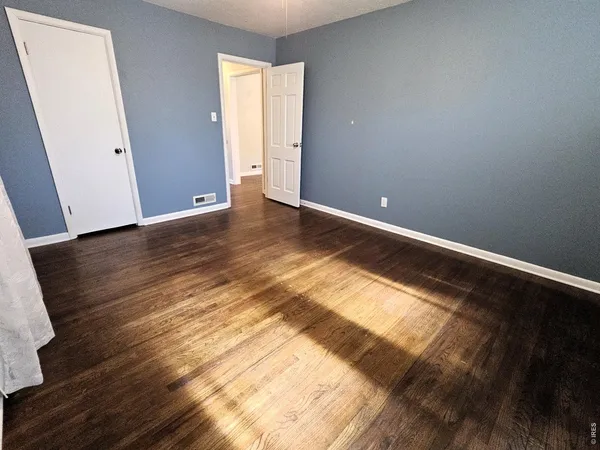 a view of an empty room and wooden floor
