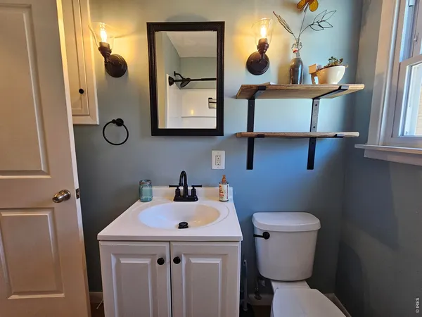 a bathroom with a toilet sink and mirror