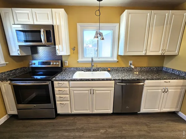 a kitchen with stainless steel appliances granite countertop a stove a microwave and a sink