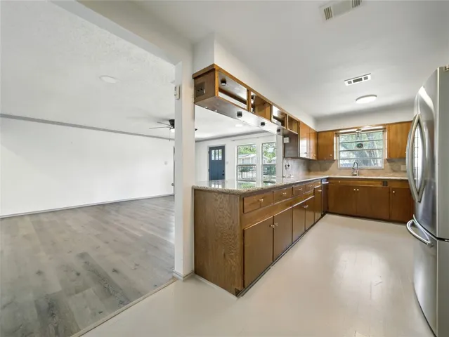 a large kitchen with stainless steel appliances granite countertop a sink and cabinets