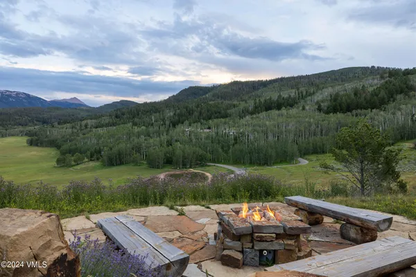 a view of a patio with lawn chairs fire pit and a yard