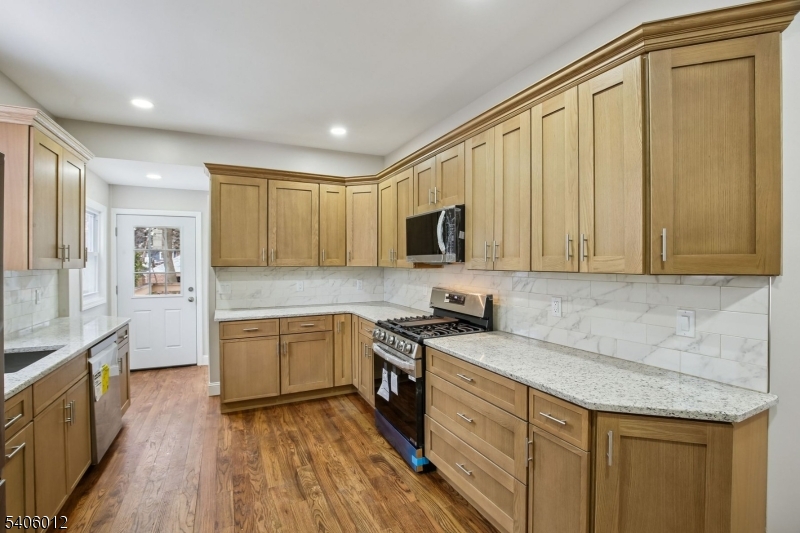 99 Lincoln Street Montclair, NJ 07042 - Photo 17 of 28 a kitchen with granite countertop cabinets stainless steel appliances a sink and wooden floor