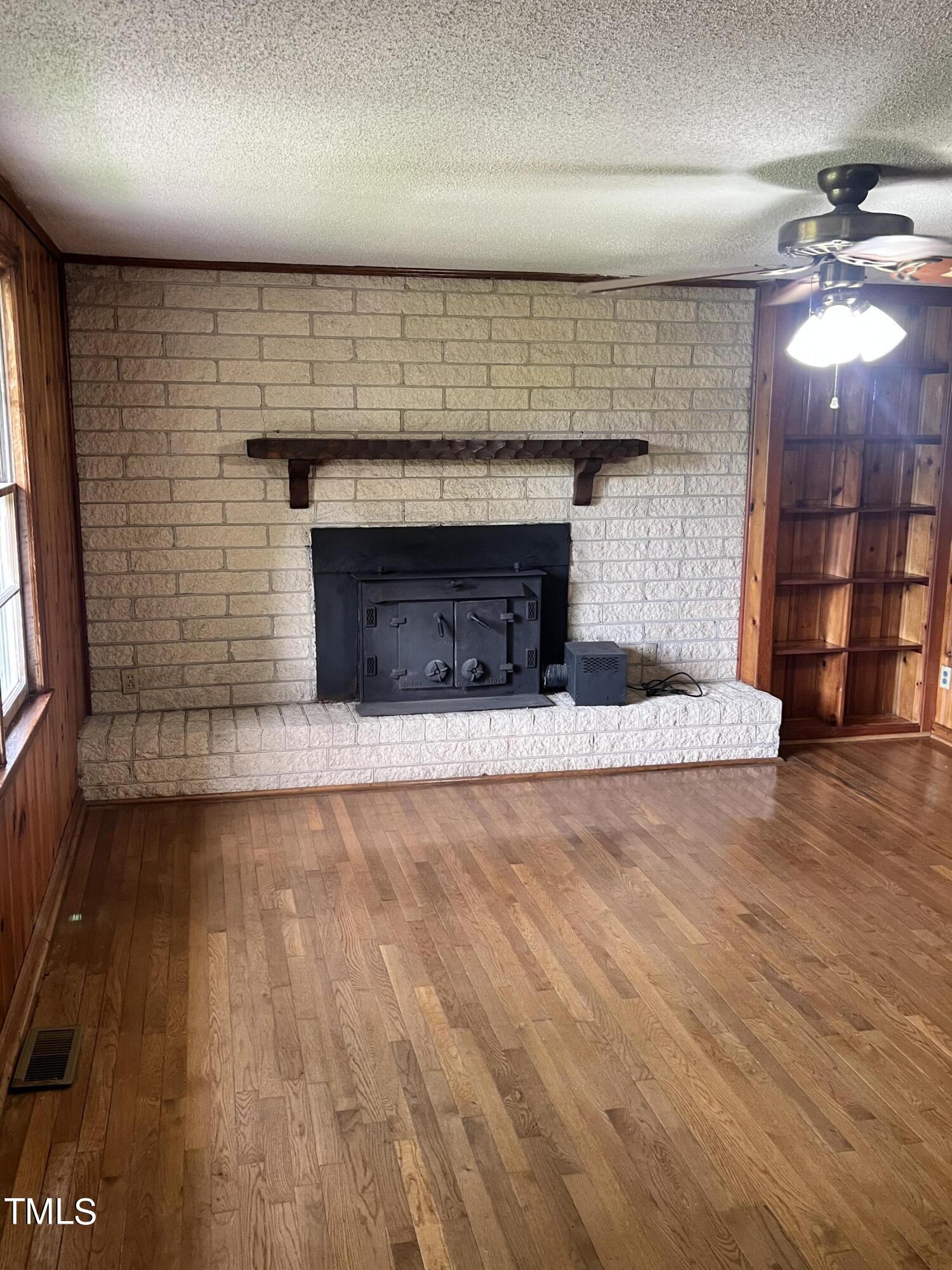 3226 Bunnlevel Erwin Road Erwin, NC 28339 - Photo 13 of 21 an empty room with wooden floor and fireplace