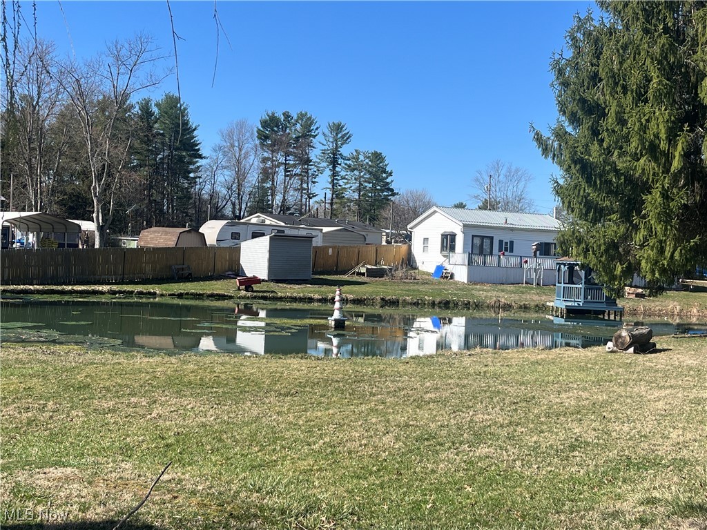 57894 Flamingo Road Senecaville, OH 43780 - Photo 4 of 20 View of yard with a shed, a water view, an outdoor structure, and fence