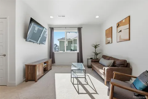 a living room with furniture a desk and chair with wooden floor