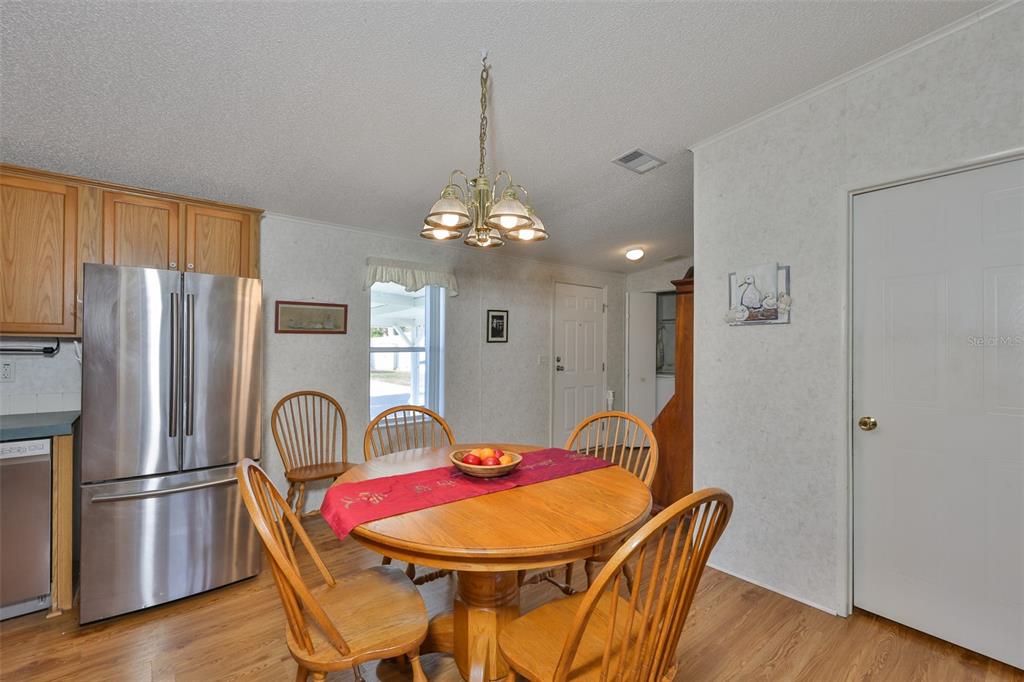 980 7th Street Northwest, Unit 16 Largo, FL 33770 - Photo 7 of 35 a dining room with furniture a chandelier and wooden floor