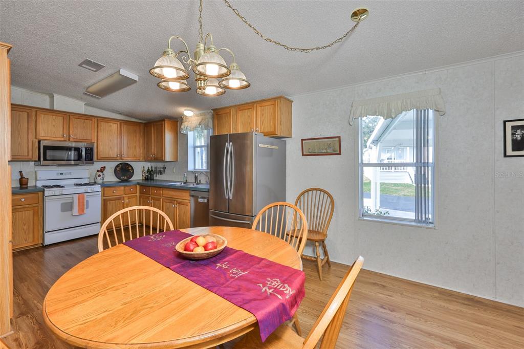 980 7th Street Northwest, Unit 16 Largo, FL 33770 - Photo 8 of 35 a kitchen with stainless steel appliances granite countertop a kitchen island hardwood floor sink stove dining table and chairs