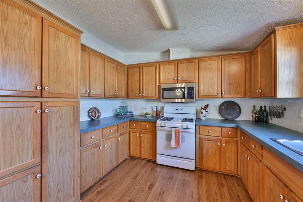 980 7th Street Northwest, Unit 16 Largo, FL 33770 - Photo 9 of 35 a kitchen with stainless steel appliances granite countertop wooden cabinets a sink a stove a refrigerator and cabinets
