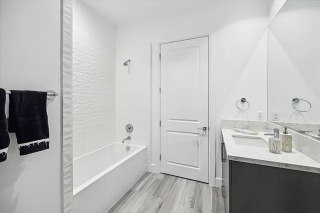 a bathroom with a bathtub a sink a vanity and a shower