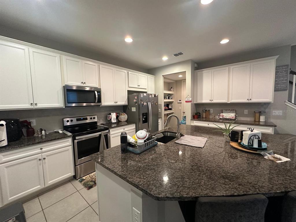 2101 Sunset Wind Loop Oldsmar, FL 34677 - Photo 2 of 13 a kitchen with sink a stove and cabinets