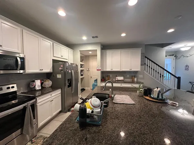 a kitchen with sink refrigerator and cabinets