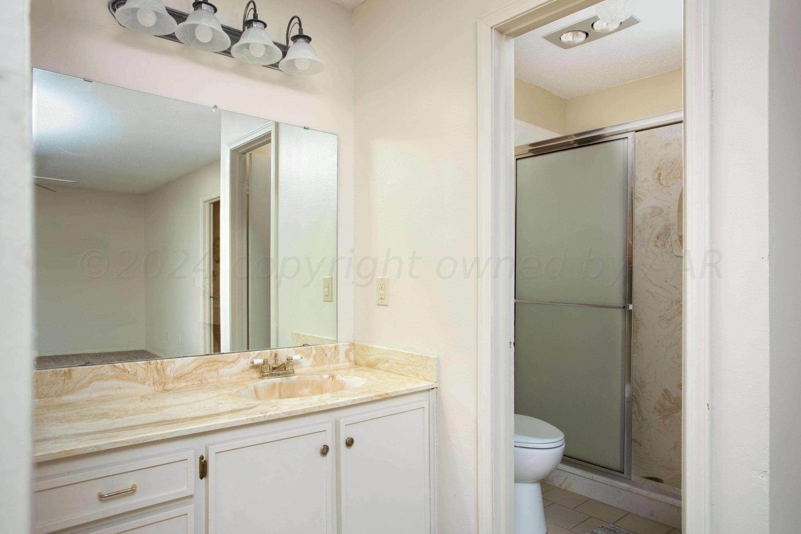 8328 Lamount Drive Amarillo, TX 79110 - Photo 14 of 24 a bathroom with a granite countertop sink toilet and shower