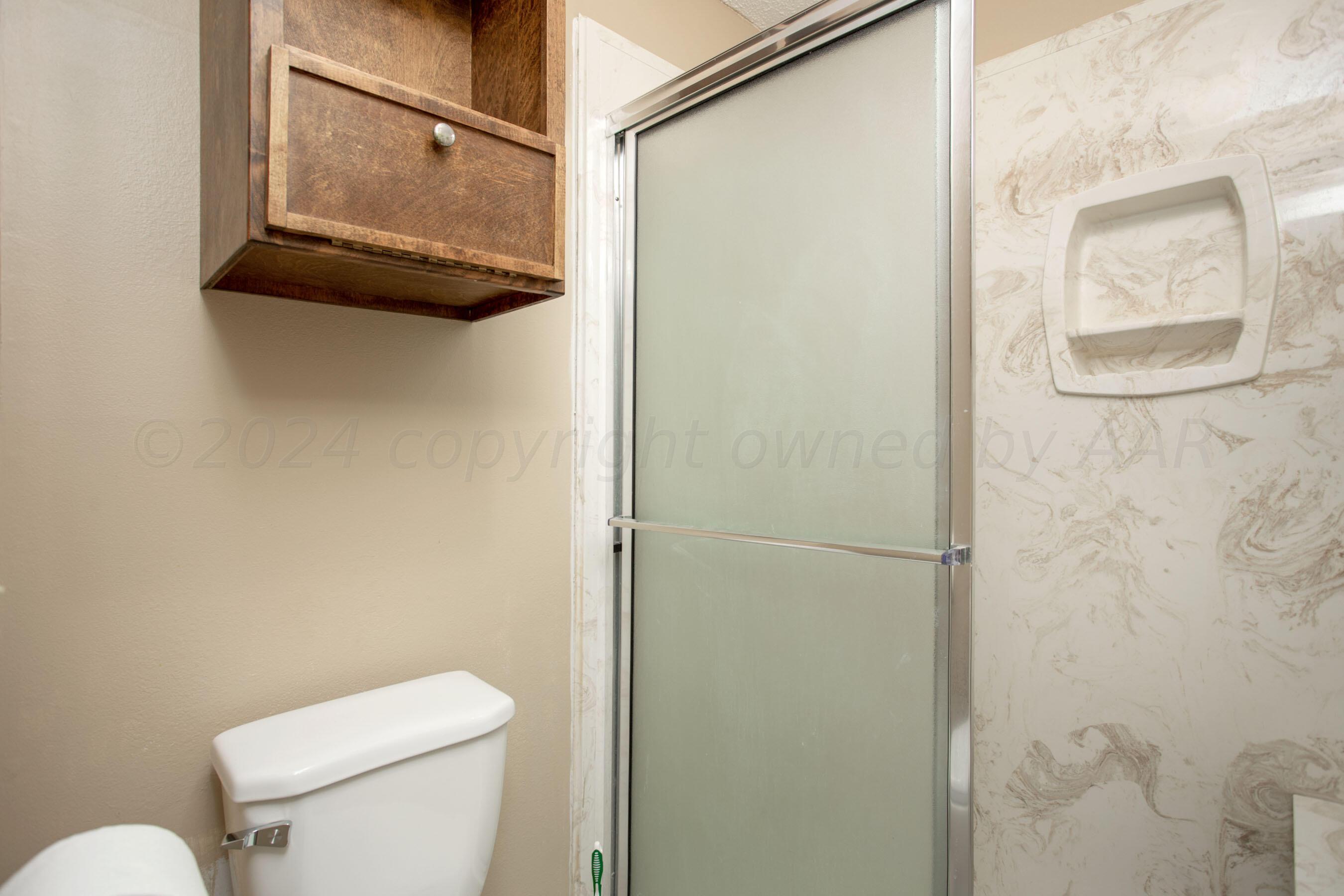 8328 Lamount Drive Amarillo, TX 79110 - Photo 15 of 24 a white toilet sitting next to a shower curtain