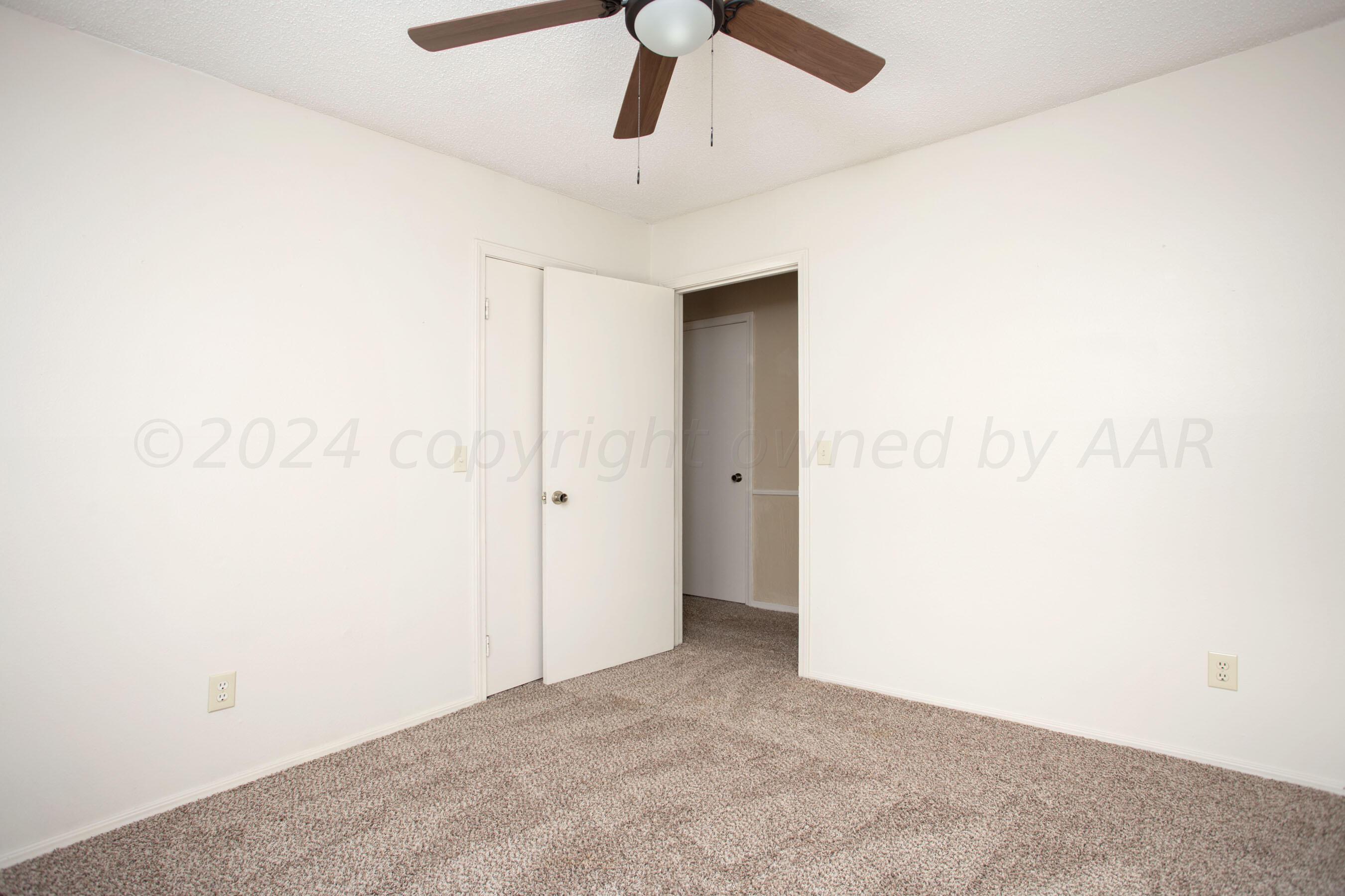 8328 Lamount Drive Amarillo, TX 79110 - Photo 16 of 24 an empty room with a ceiling fan and carpet