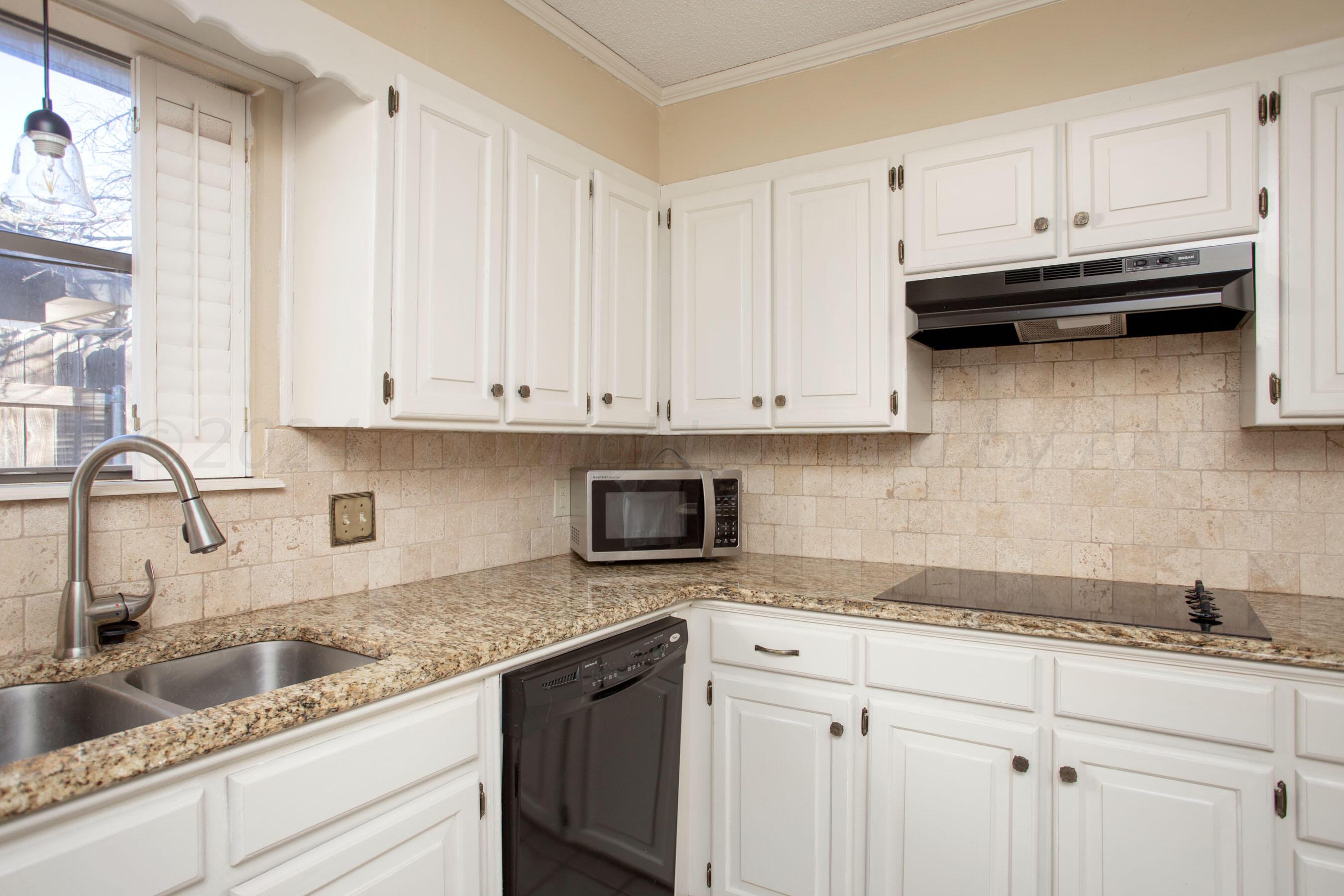 8328 Lamount Drive Amarillo, TX 79110 - Photo 3 of 24 a kitchen with granite countertop white cabinets and a sink