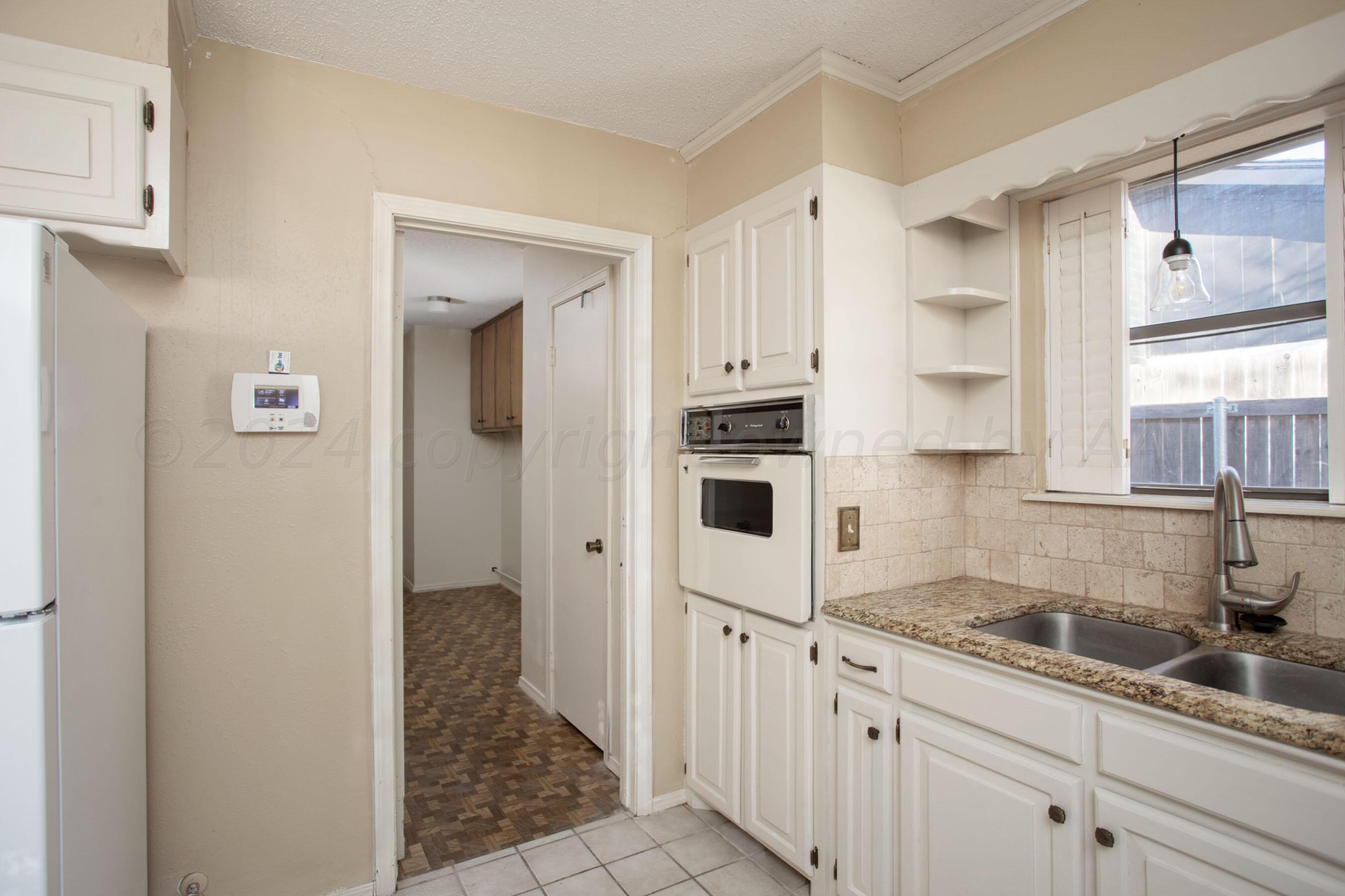 8328 Lamount Drive Amarillo, TX 79110 - Photo 4 of 24 a kitchen with white cabinets and white appliances