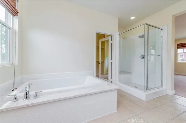 a spacious bathroom with a tub shower and mirror