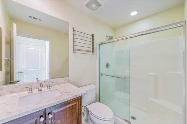 a bathroom with a granite countertop sink toilet a mirror and shower