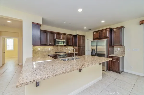 a kitchen with stainless steel appliances granite countertop a sink refrigerator and cabinets