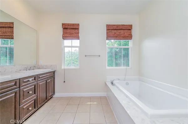 a spacious bathroom with a granite countertop bathtub a sink and a window