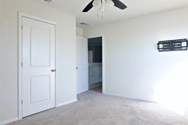 an empty room with chandelier fan