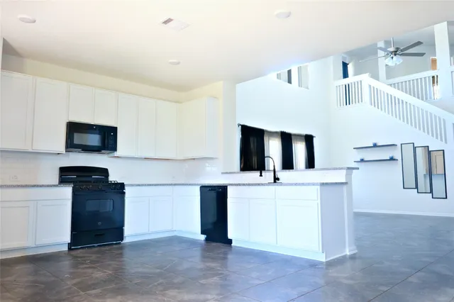 a view of kitchen with sink microwave and refrigerator