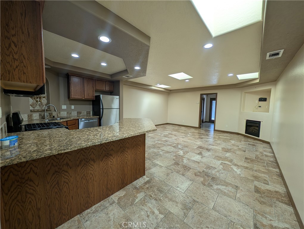 27160 Vista Road, Unit 21 Helendale, CA 92342 - Photo 8 of 11 a large kitchen with stainless steel appliances granite countertop a large counter top a stove a sink and a refrigerator