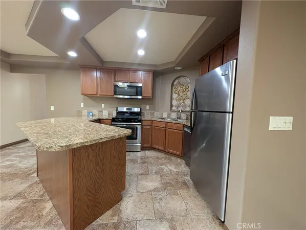 a kitchen with kitchen island a counter top space cabinets stainless steel appliances and a counter top space