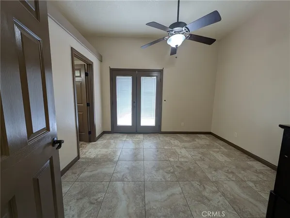 a view of an empty room with a chandelier fan
