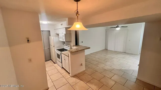 a kitchen with stainless steel appliances granite countertop a sink a stove a refrigerator and cabinets