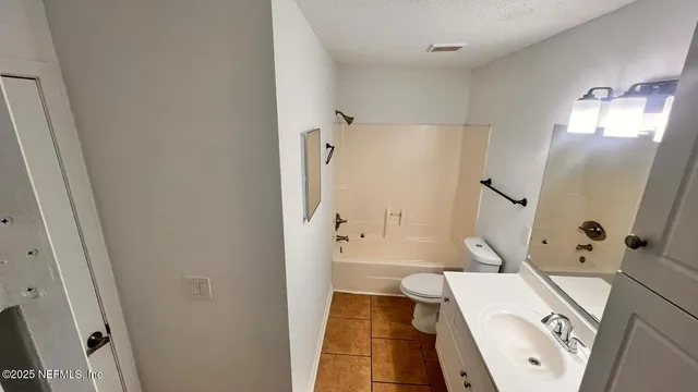 an empty room with wooden floor and a ceiling fan