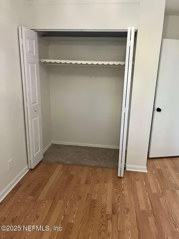 an empty room with wooden floor and entrance