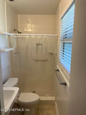 a bathroom with a toilet and a shower