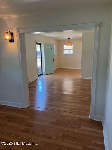 a view of a living room with hardwood floor and window