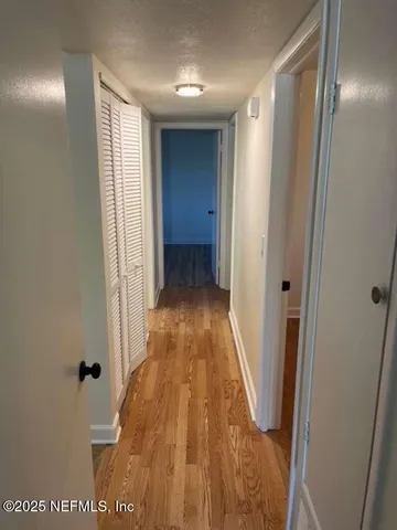 a view of a hallway with wooden floor