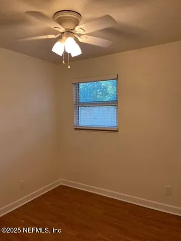 a view of a small space with wooden floor and a window