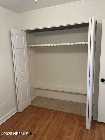 a view of walk in closet with wooden floor