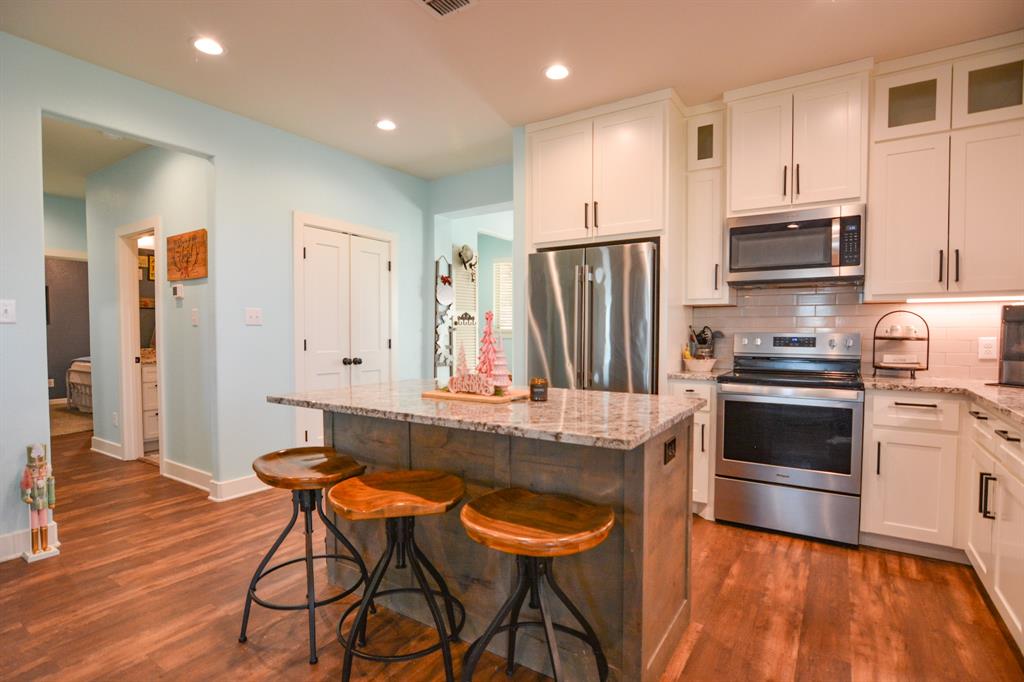 601 Mathew Street Grandview, TX 76050 - Photo 12 of 40 a kitchen with stainless steel appliances kitchen island granite countertop a stove a sink and a refrigerator