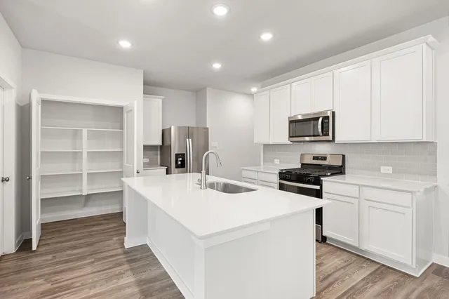 a kitchen that has a sink a stove and cabinets