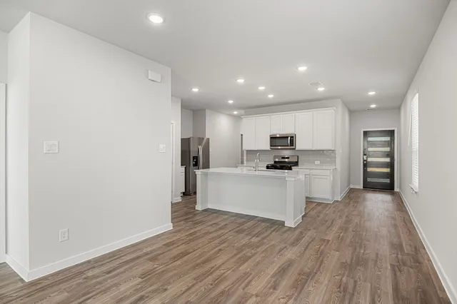a kitchen with white cabinets and stainless steel appliances