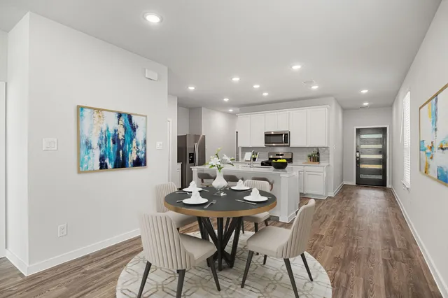 a kitchen with a dining table chairs and refrigerator