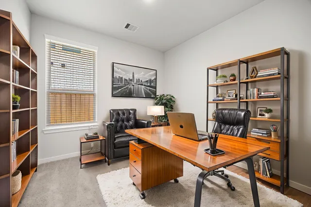 a view of a workspace with furniture and a bookshelf