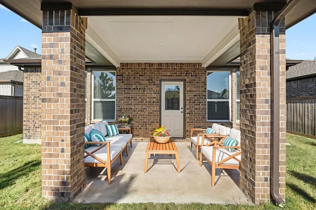 a view of a patio with couple of chairs and potted plants
