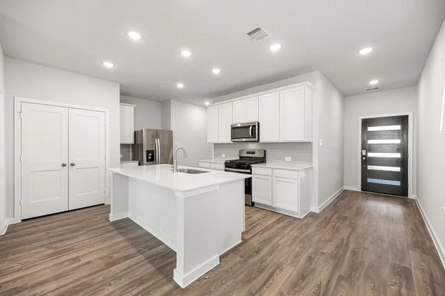 a kitchen with white cabinets and white appliances