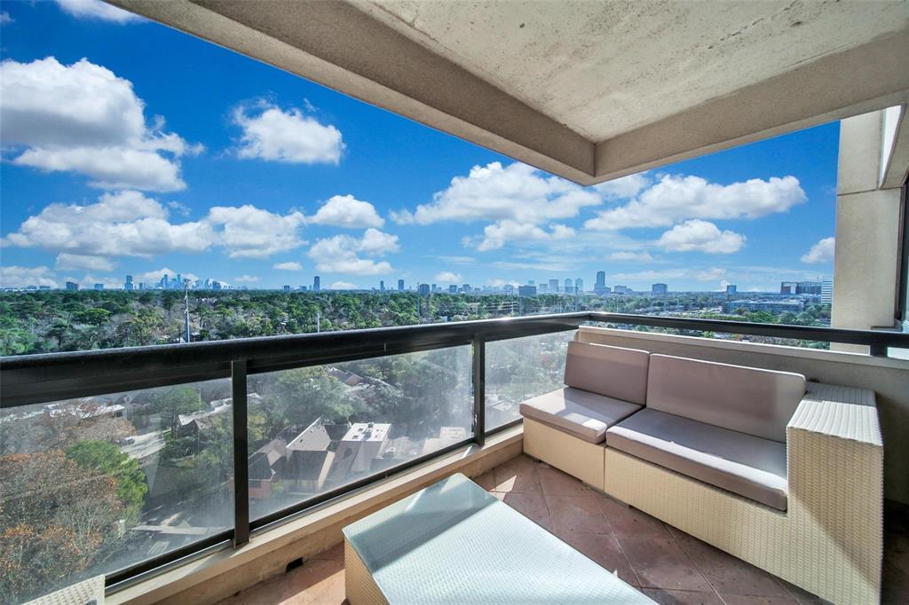 a view of a balcony with furniture and city view
