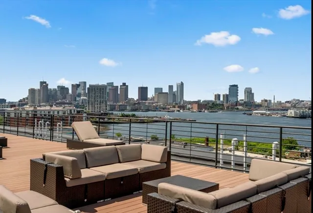 a view of a roof deck with couches and potted plants